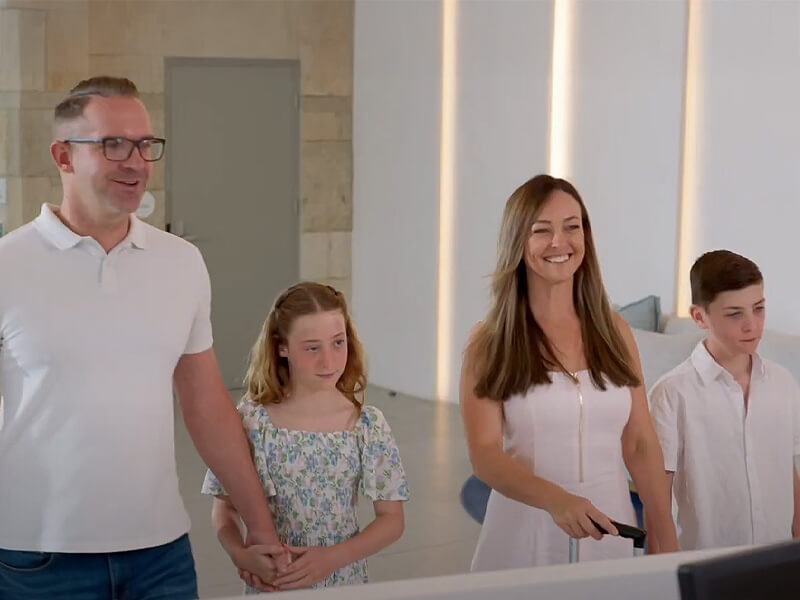 Family with two children checking in and exploring their apartment at ULTIQA Signature, enjoying resort pools, amenities, and facilities.