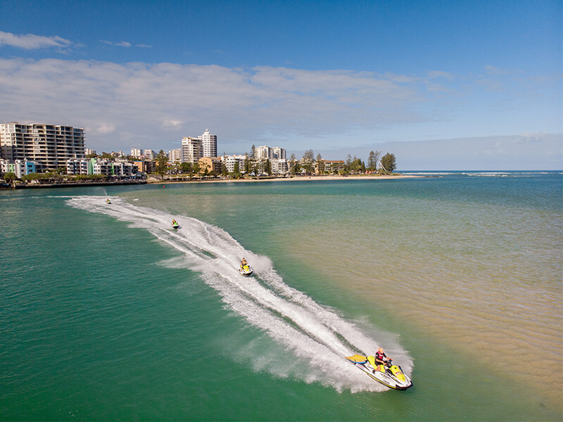 People riding jet skis along the Caloundra waterfront.