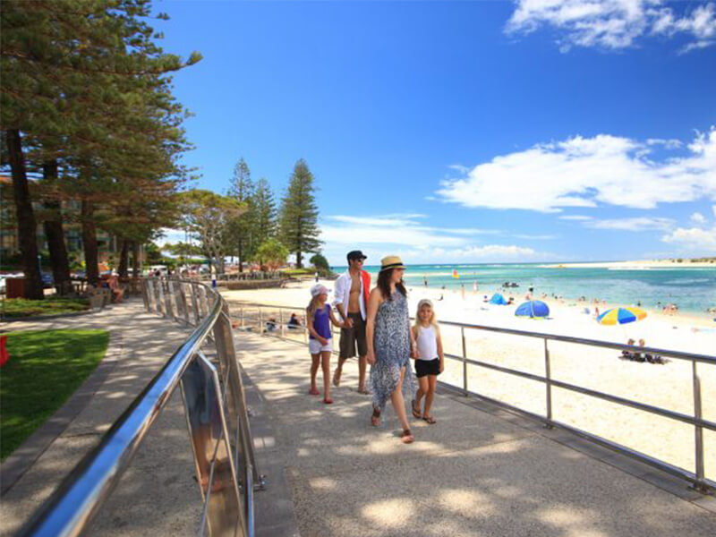 Family walking along the Caloundra beachfront promenade.