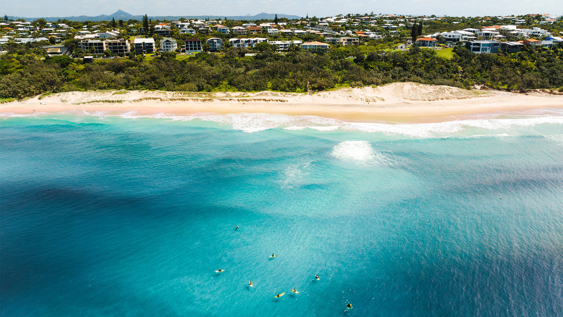 Aerial view of kayakers in turquoise waters off the Sunshine Coast.