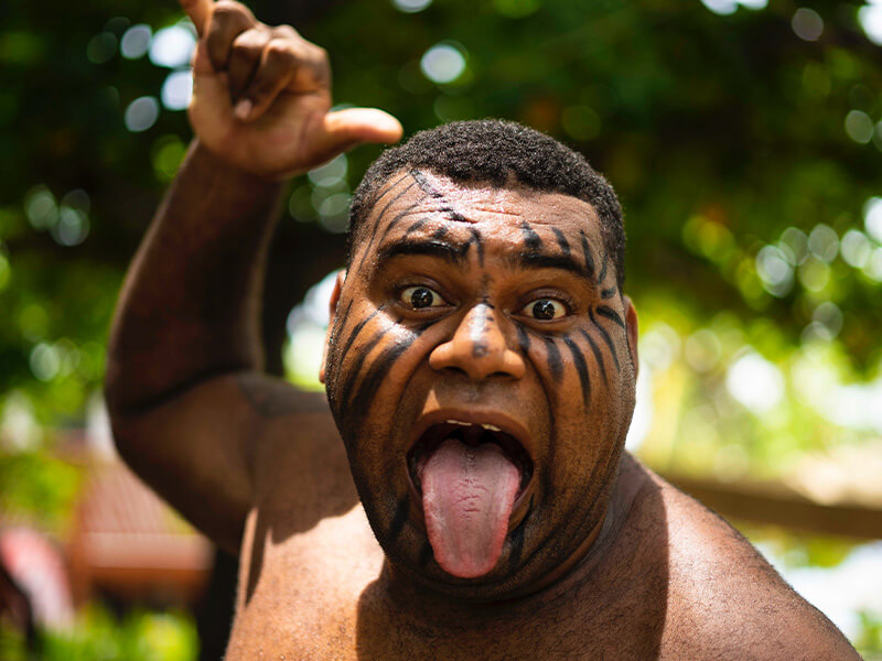 Performer with traditional face paint during a cultural show in Fiji.