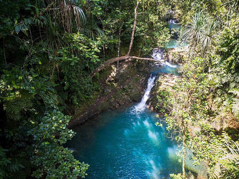 Waterfalls and turquoise pools surrounded by lush rainforest in Fiji.