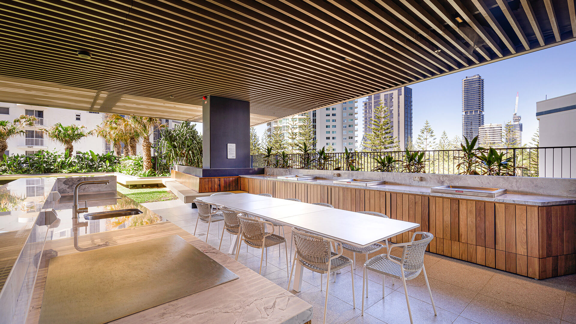 Outdoor BBQ and dining area at ULTIQA Signature with modern seating and city views.
