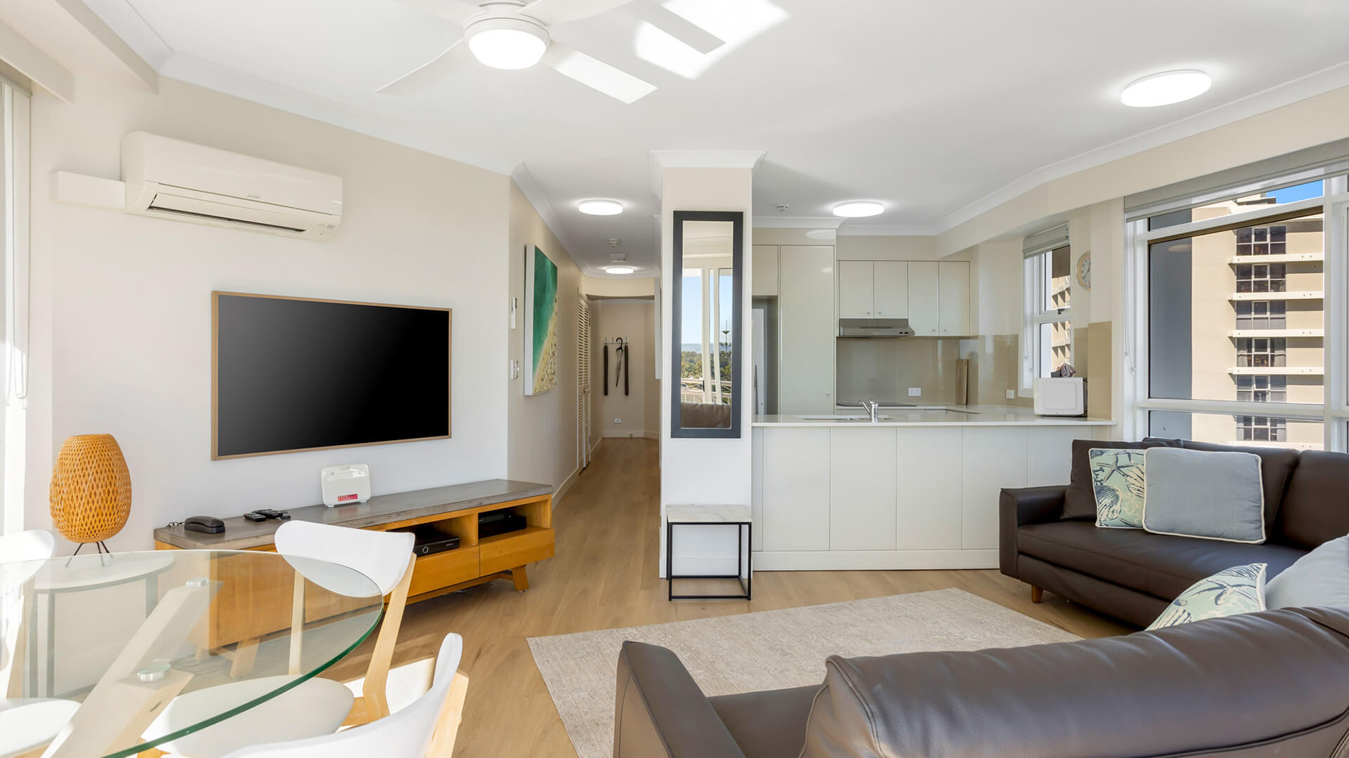 Bright living area and kitchen with comfy seating, TV, and full kitchen.