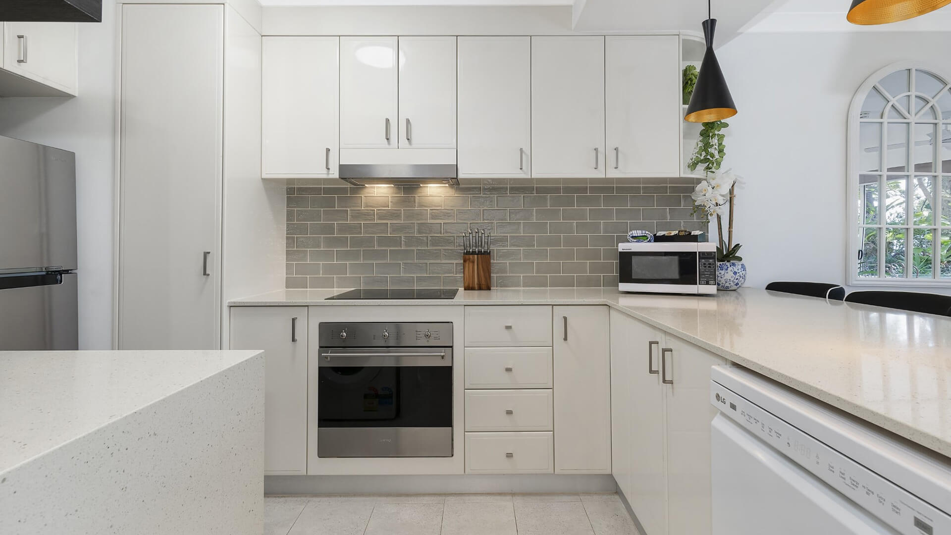 Spacious lounge in 1 Bedroom Superior Apartment at ULTIQA Burleigh Mediterranean Resort with garden views and outdoor access.