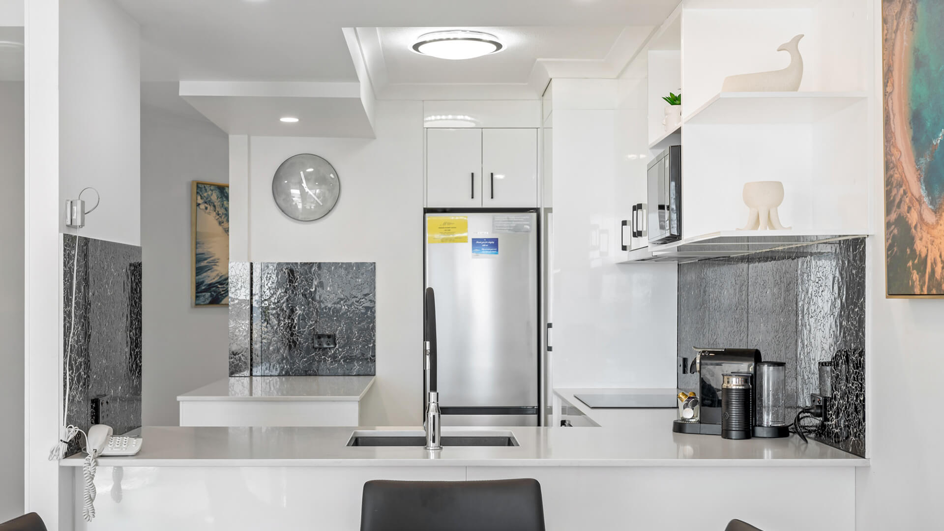 Contemporary kitchen and dining area in 1 Bedroom Superior Ocean View Apartment at ULTIQA Burleigh Mediterranean Resort.