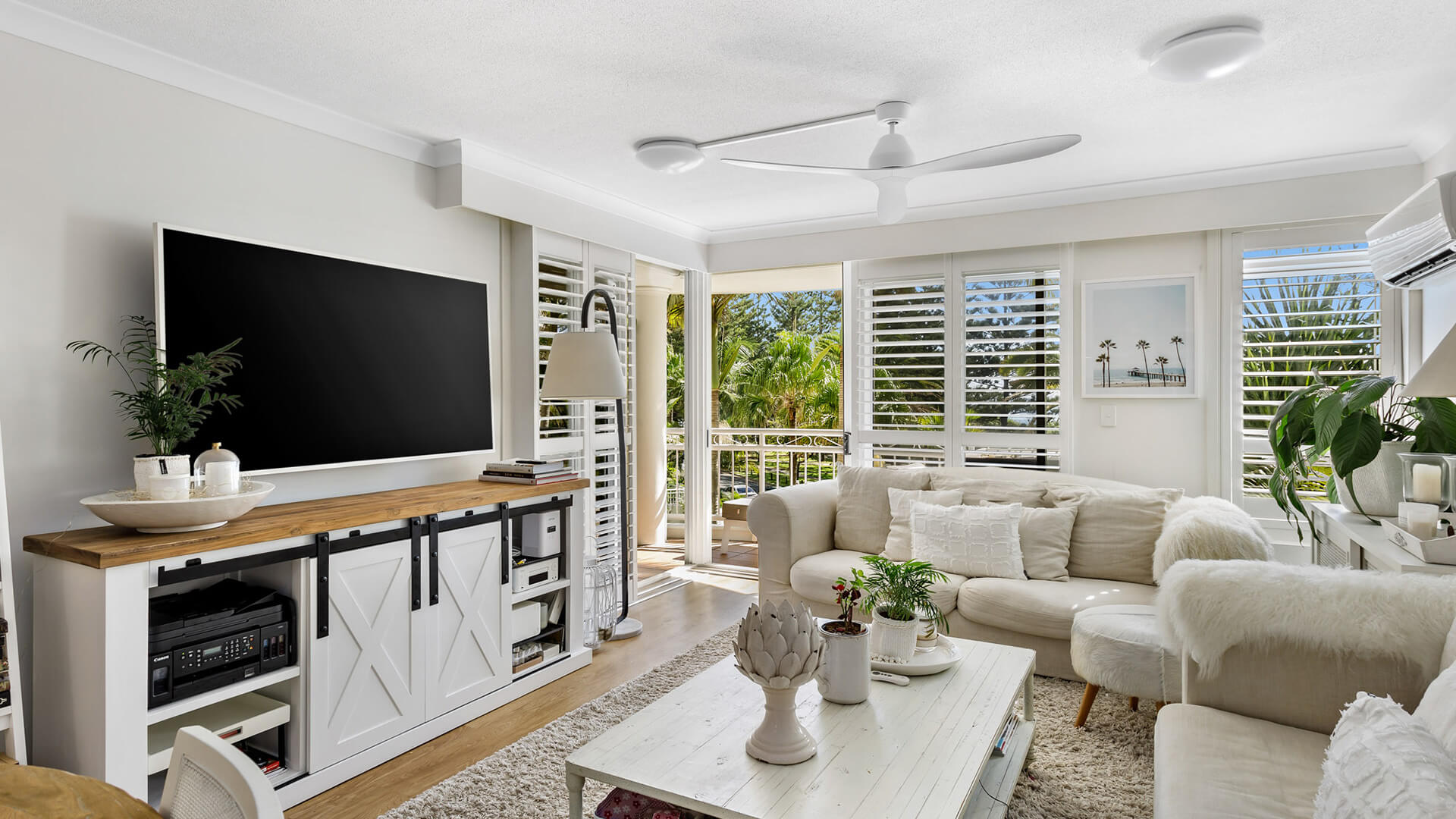Living area of 2 Bedroom Superior Apartment at ULTIQA Burleigh Mediterranean Resort with coastal décor and balcony access.