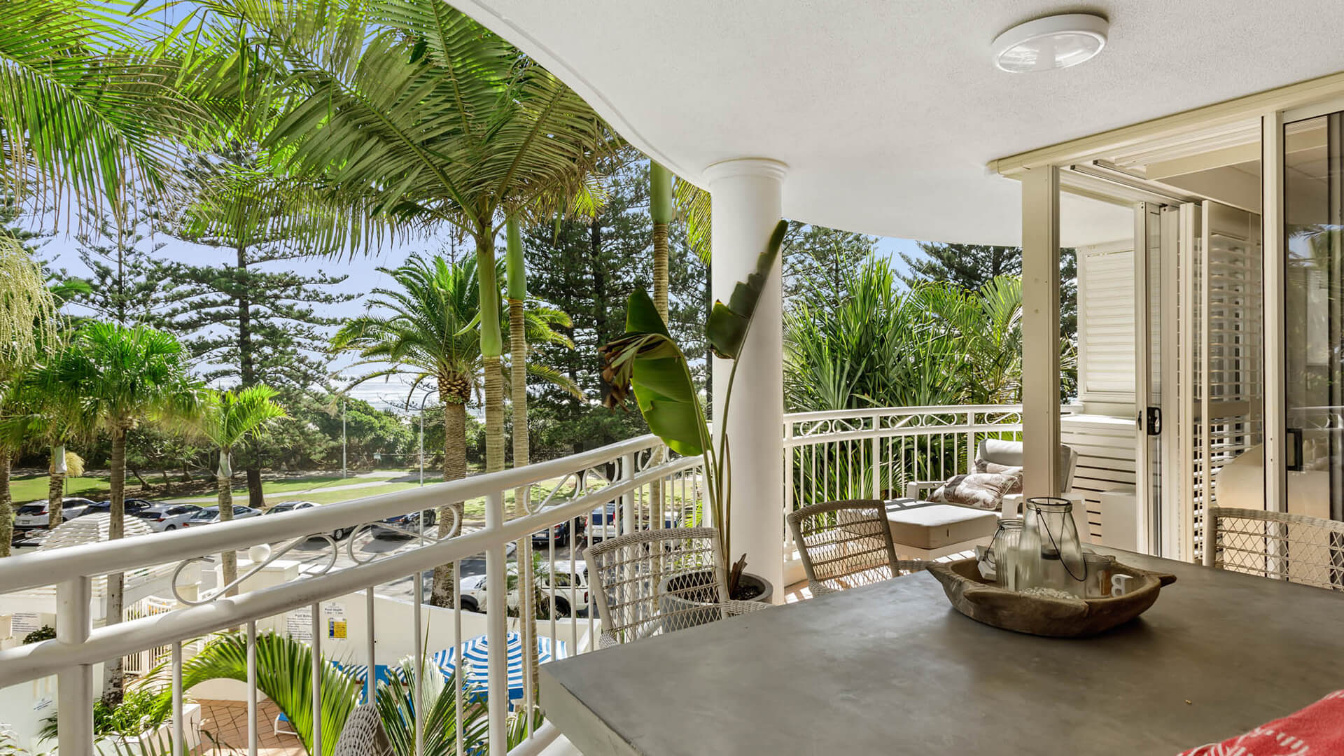 Private balcony with outdoor seating and garden views in 2 Bedroom Garden View Apartment at ULTIQA Burleigh Mediterranean Resort.