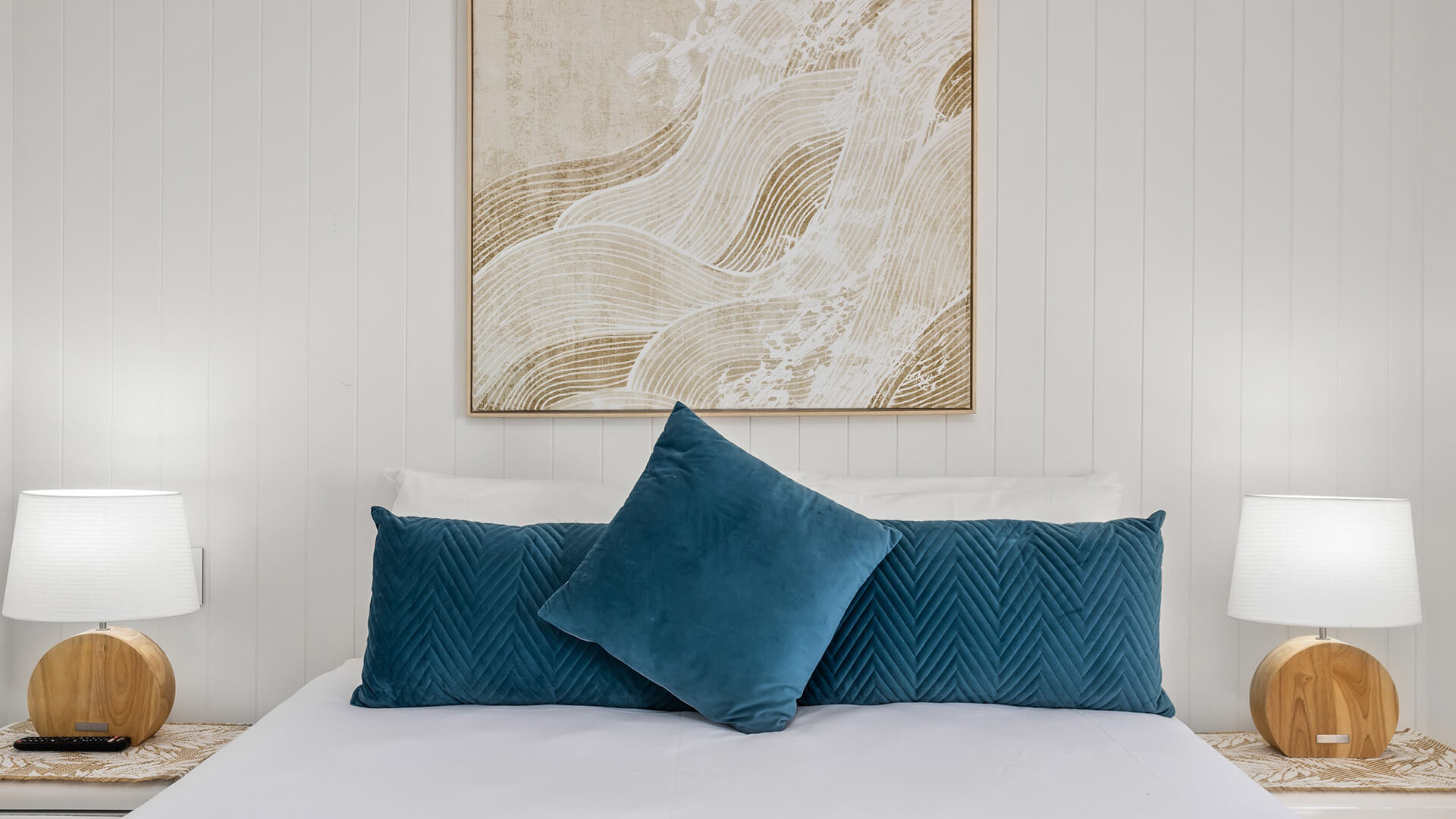 King bed with teal accents in 2 Bedroom Superior Ocean View Apartment at ULTIQA Burleigh Mediterranean Resort.