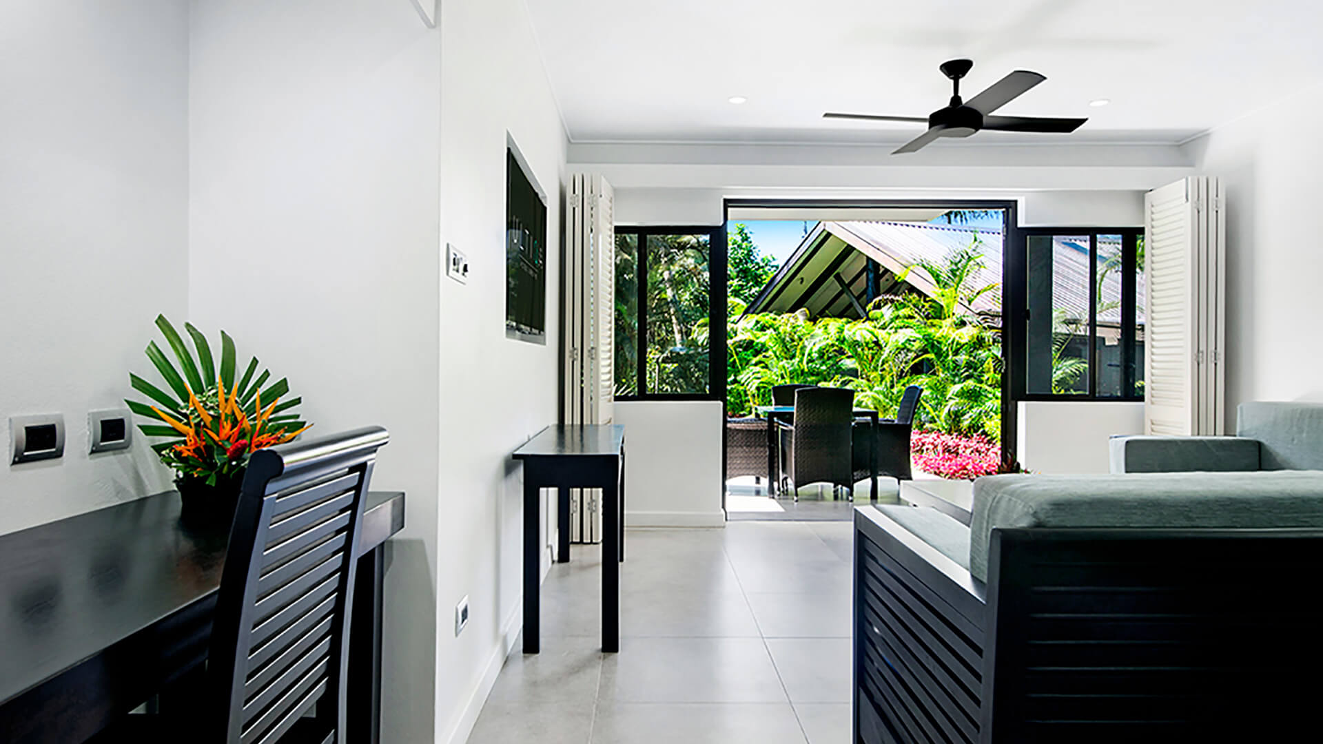 2 Bedroom Apartment at ULTIQA Fiji with desk, lounge, and patio overlooking tropical gardens.