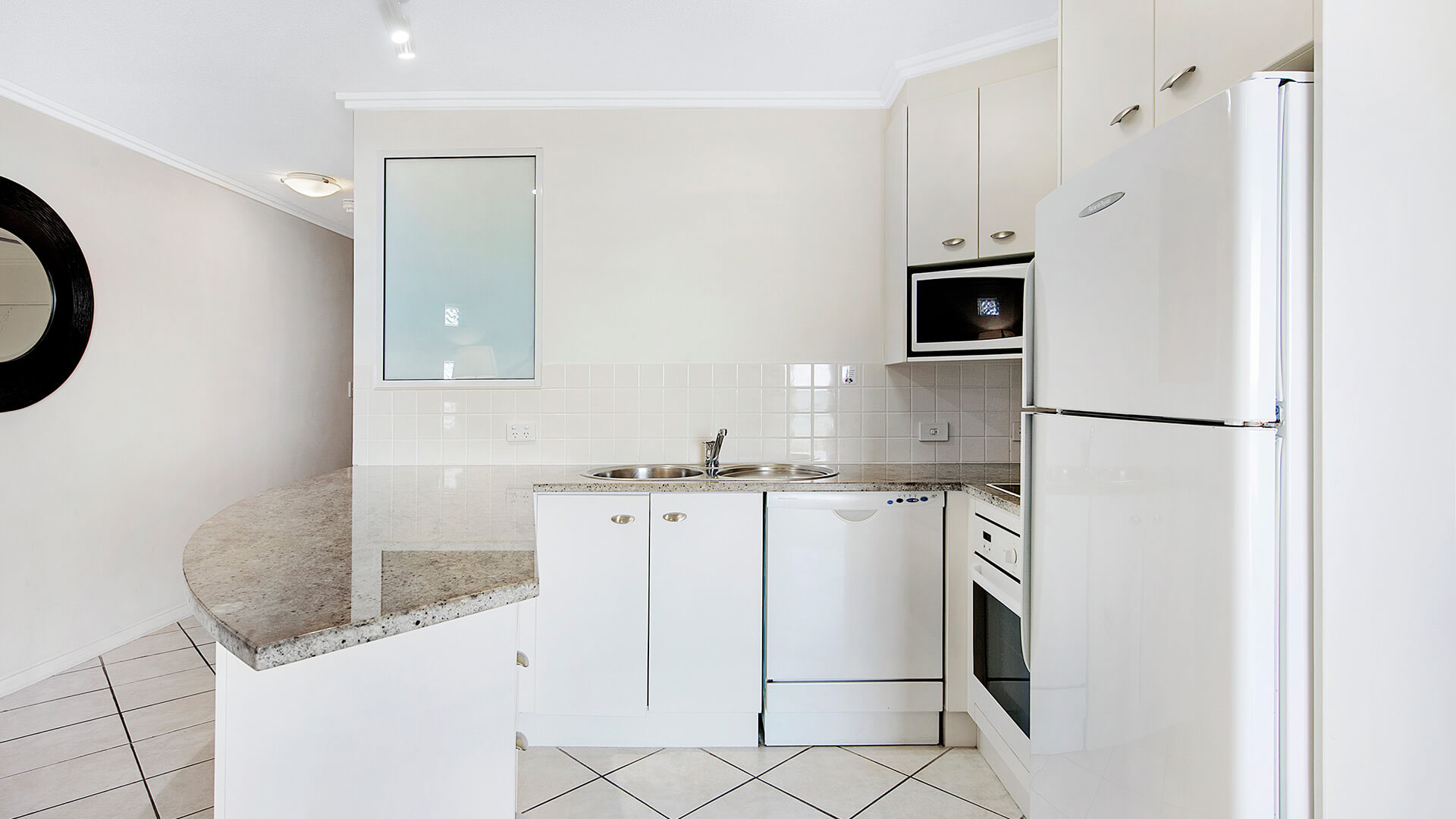 Kitchen with granite benchtop in 1 Bedroom Apartment at ULTIQA Shearwater Resort.