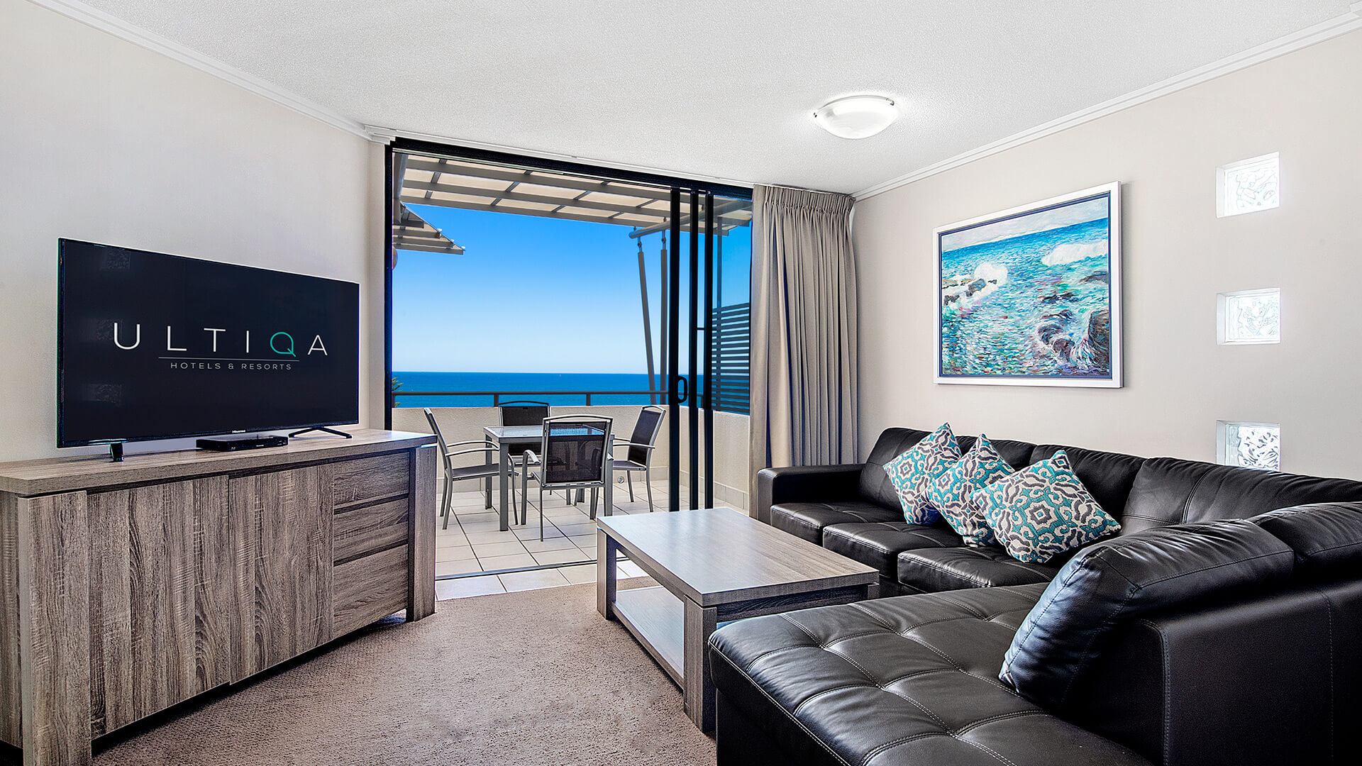 Living area with ocean-view balcony in 2 Bedroom 1 Bathroom Apartment at ULTIQA Shearwater Resort.
