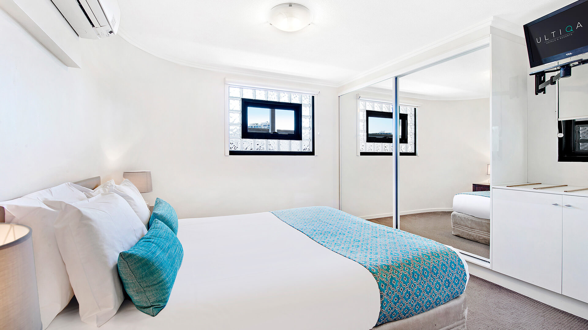 Bedroom with mirrored wardrobe in 2 Bedroom 1 Bathroom Apartment at ULTIQA Shearwater Resort.