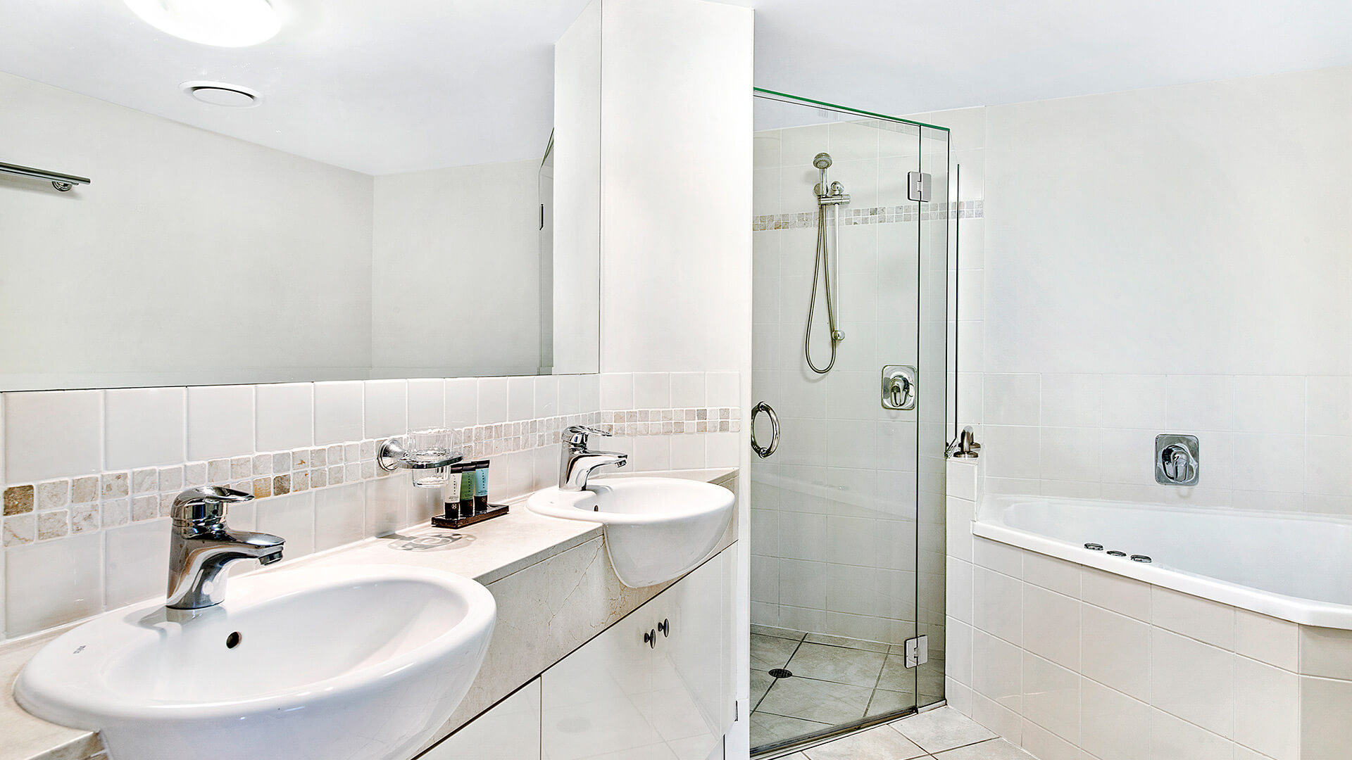Bathroom with dual sinks, shower, and bathtub in 2 Bedroom 1 Bathroom Apartment at ULTIQA Shearwater Resort.