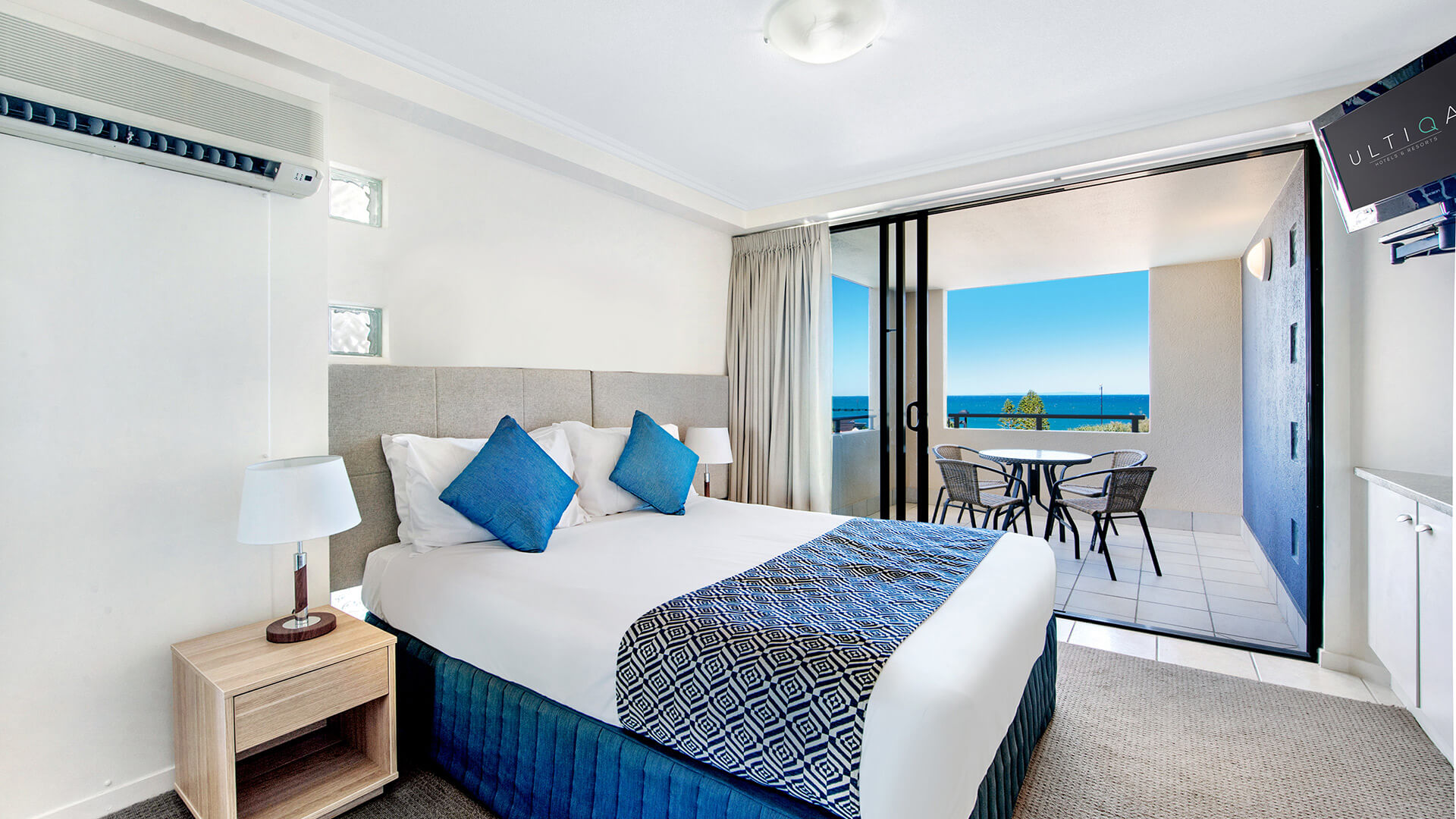 Bedroom with queen bed, TV, and balcony with ocean views in 2 Bedroom Apartment at ULTIQA Shearwater Resort.