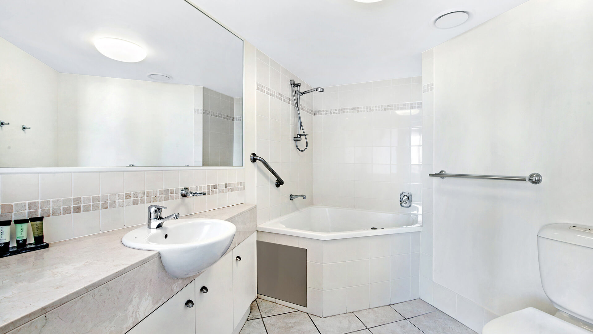 Bathroom with vanity, toilet, and spa bath in 2 Bedroom Apartment at ULTIQA Shearwater Resort.
