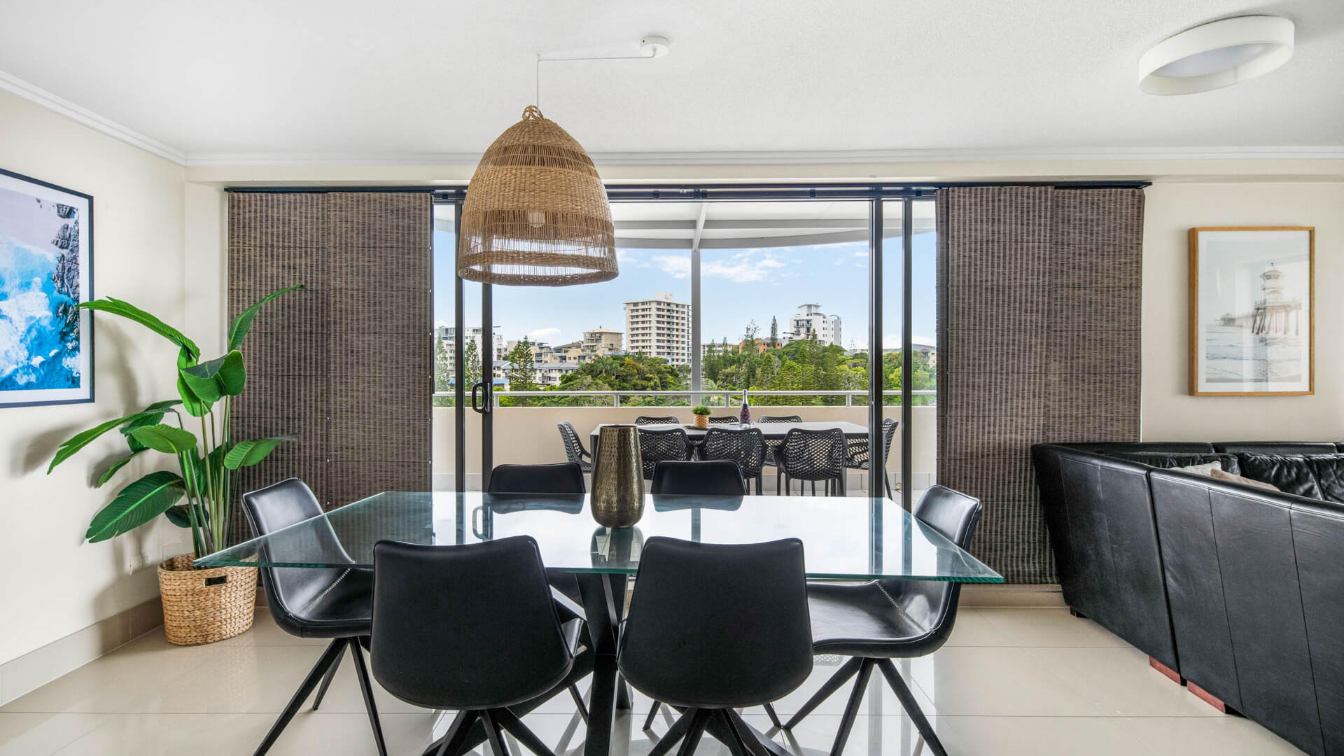 Dining area with glass table and balcony access in 3 Bedroom Penthouse at ULTIQA Shearwater Resort.