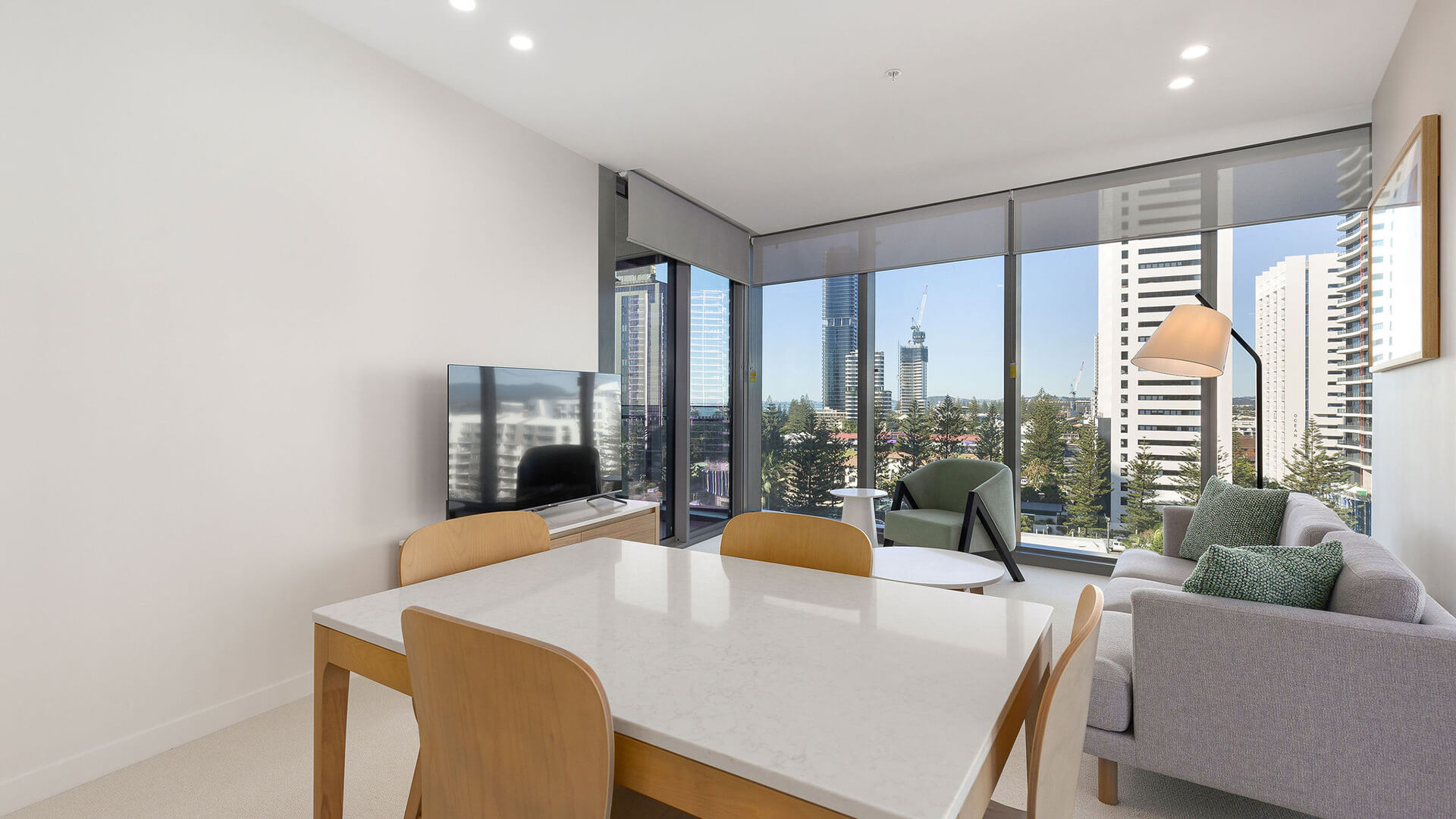 Dining and living area with city and ocean views in the 1 Bedroom Suite at ULTIQA Signature at Broadbeach.