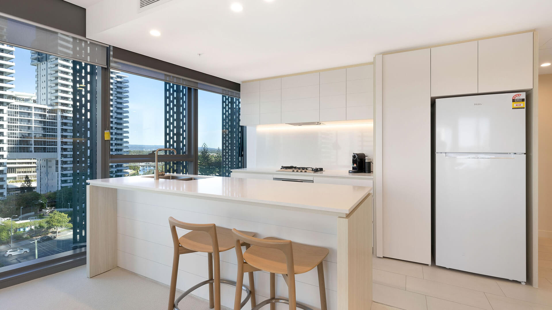 Kitchen with breakfast bar and city views in the 1 Bedroom Suite at ULTIQA Signature at Broadbeach.