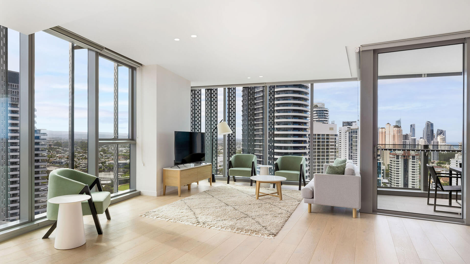 Modern living area with balcony and skyline views in the 2 Bedroom Skyhome at ULTIQA Signature at Broadbeach.