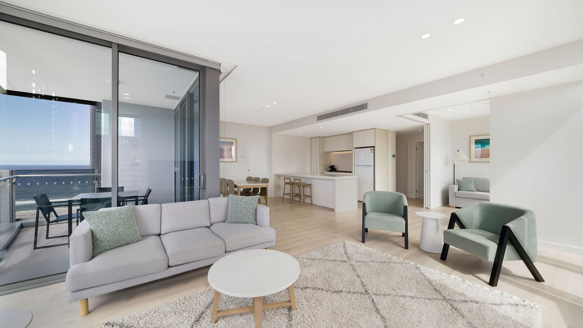 Spacious open-plan living area with ocean-view balcony in the 2 Bedroom Skyhome at ULTIQA Signature at Broadbeach.