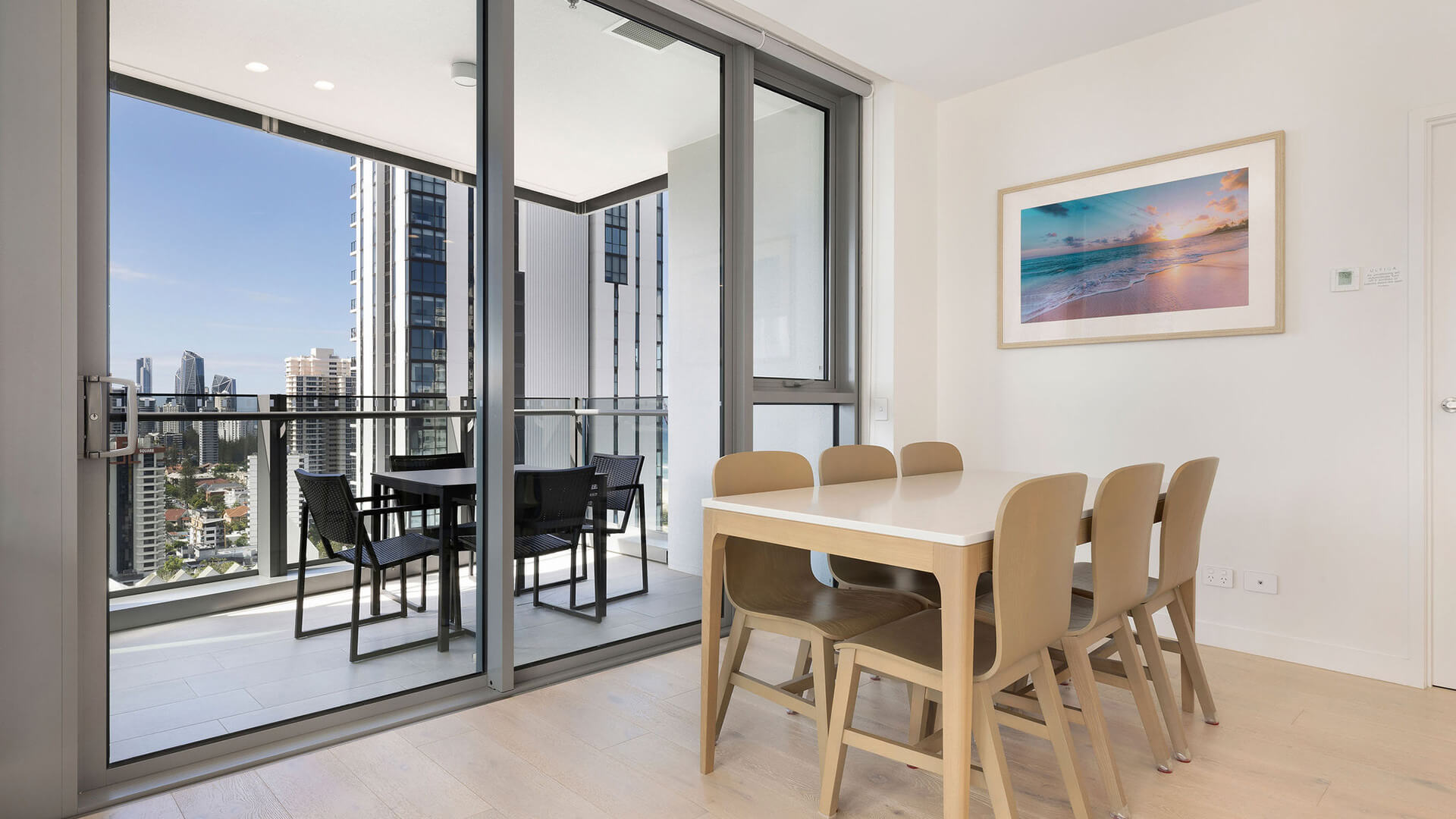 Dining area with balcony access and city views in the 2 Bedroom Skyhome at ULTIQA Signature at Broadbeach.