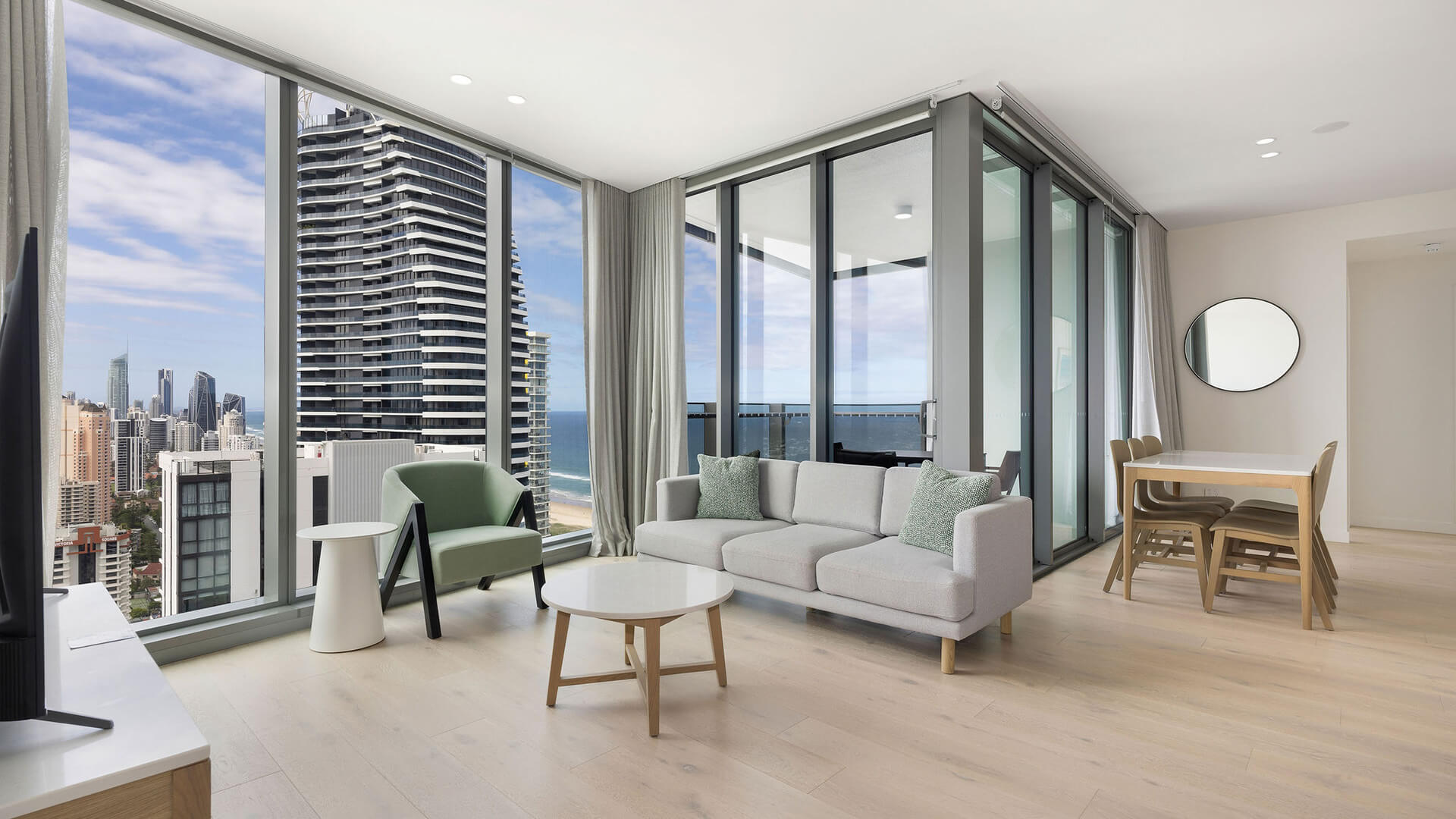 Open-plan living and dining area with floor-to-ceiling windows and stunning city and ocean views in the 2 Bedroom Skyhome at ULTIQA Signature at Broadbeach.
