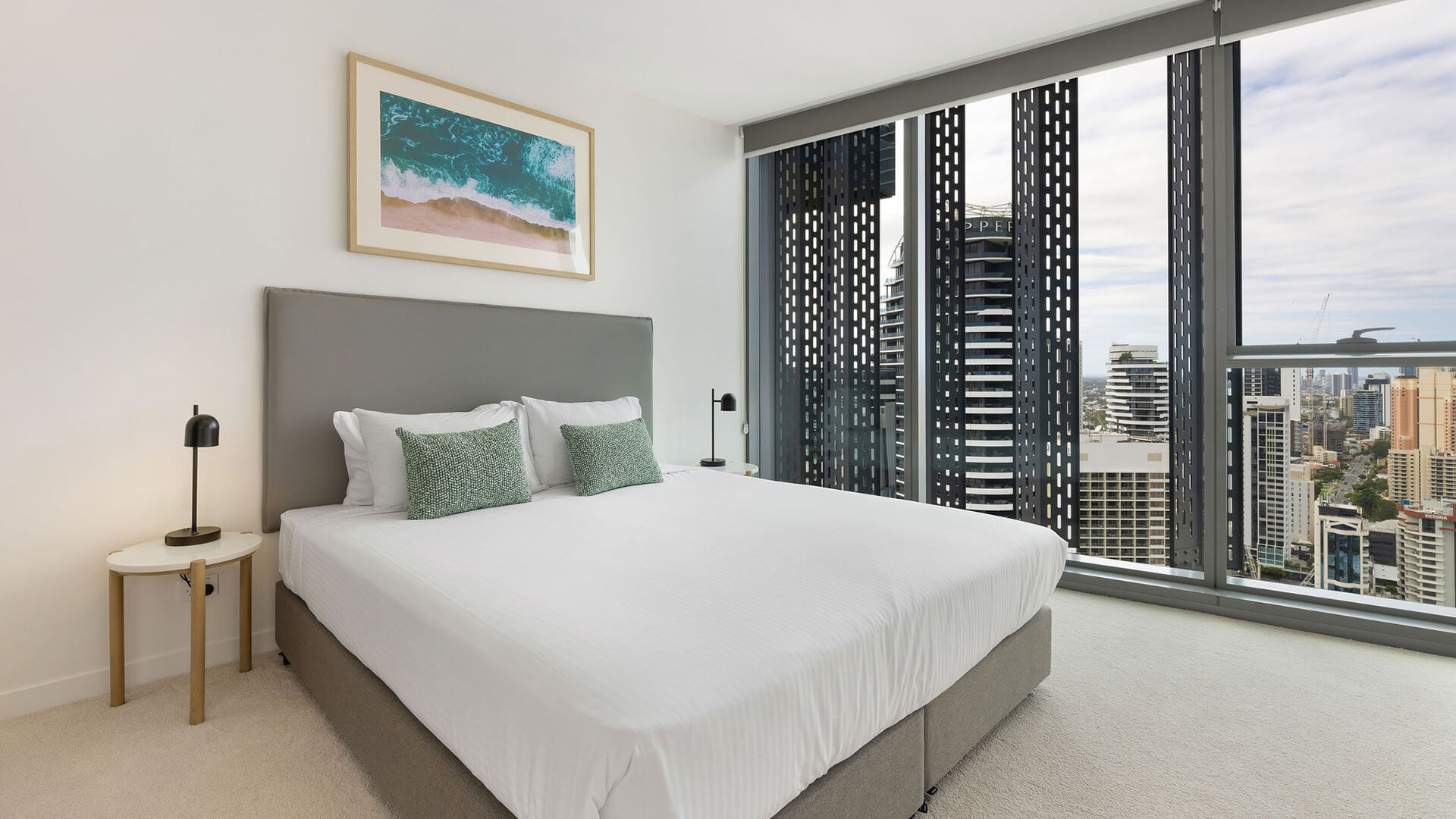 Master bedroom with king bed, modern décor, and floor-to-ceiling windows offering stunning city views in the 2 Bedroom Skyhome at ULTIQA Signature at Broadbeach.