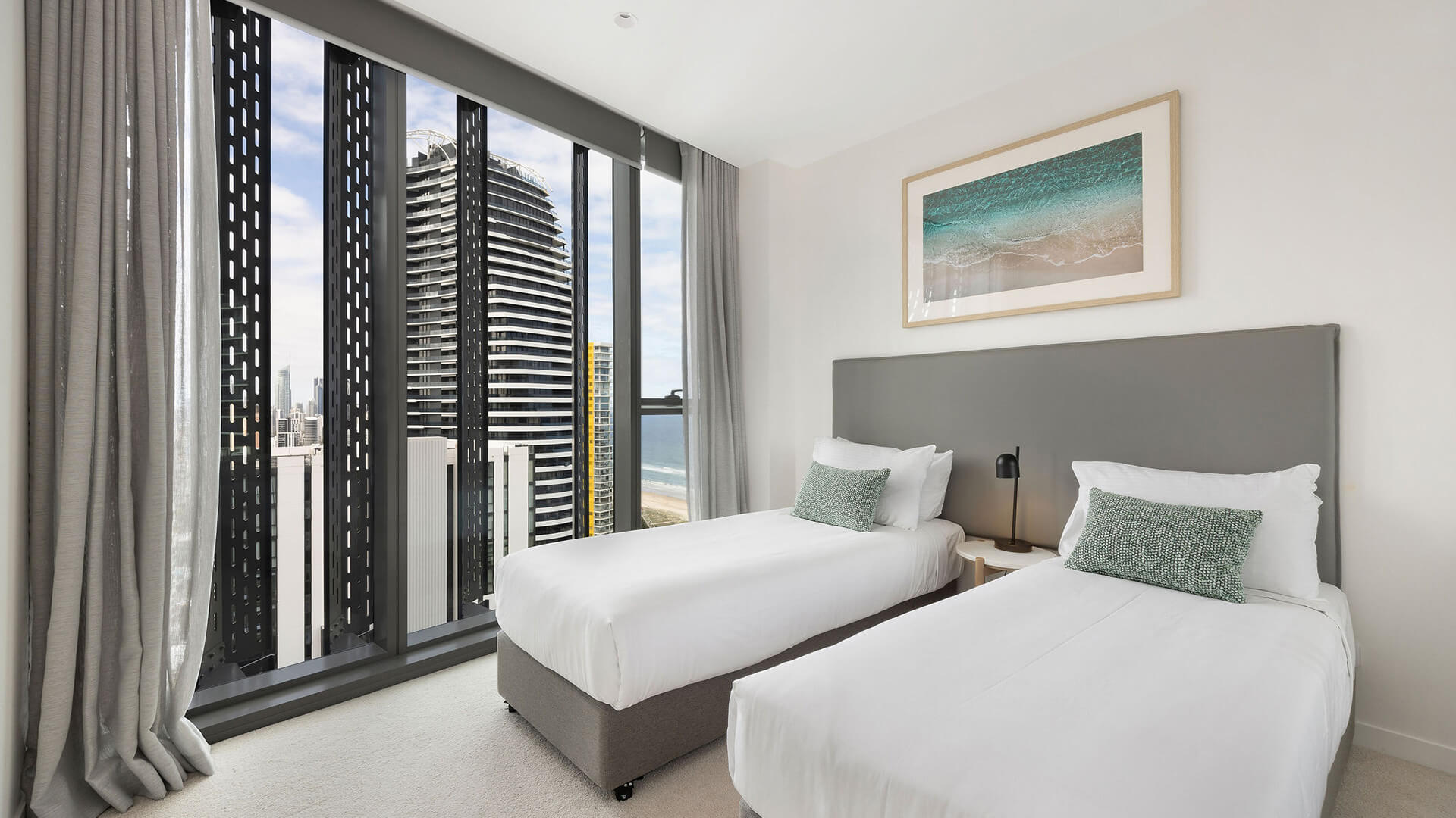 Second bedroom with two single beds, ocean views, and floor-to-ceiling windows in the 2 Bedroom Skyhome at ULTIQA Signature at Broadbeach.
