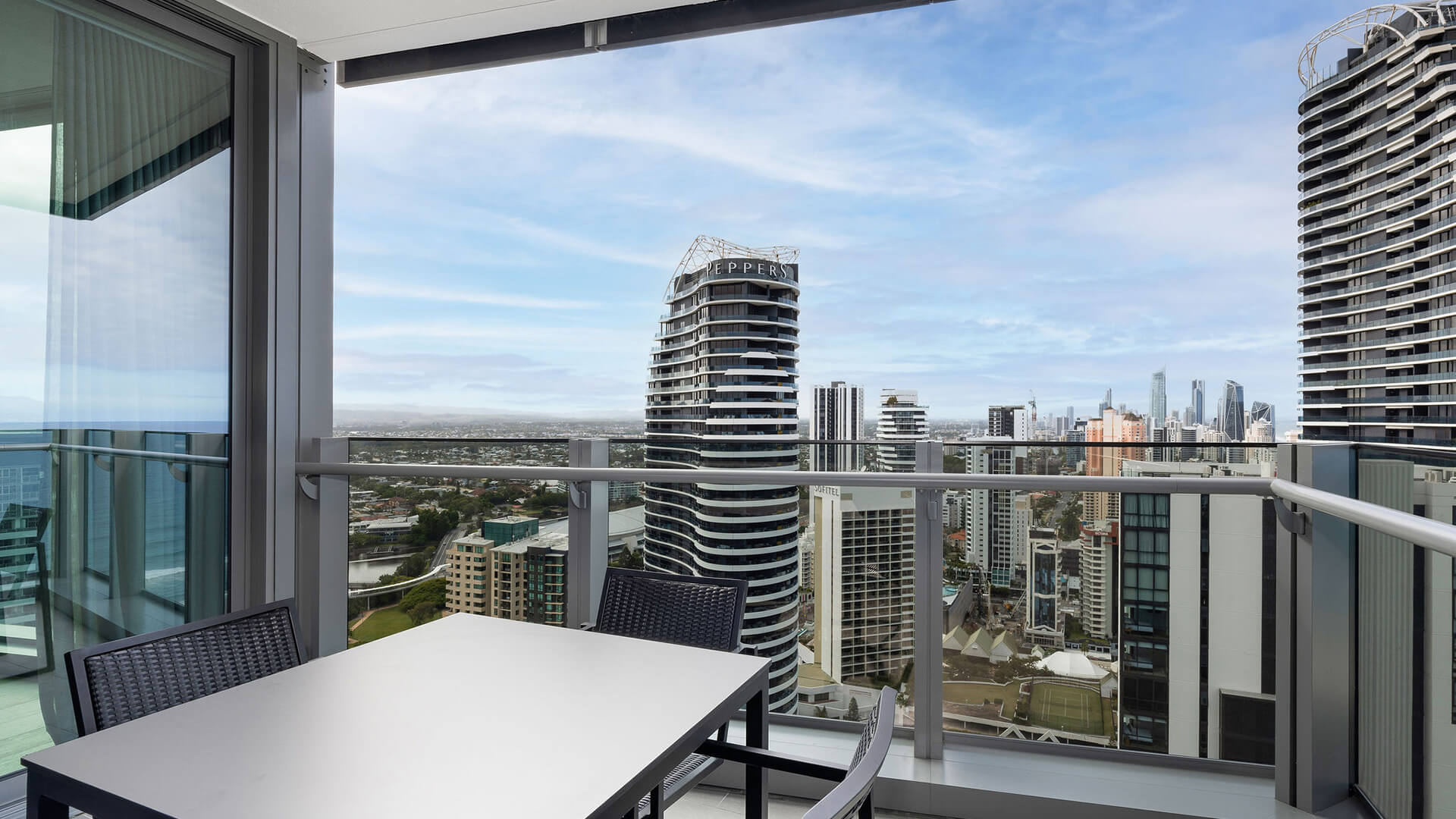 Private balcony with outdoor dining and city views in the 2 Bedroom Skyhome at ULTIQA Signature at Broadbeach.