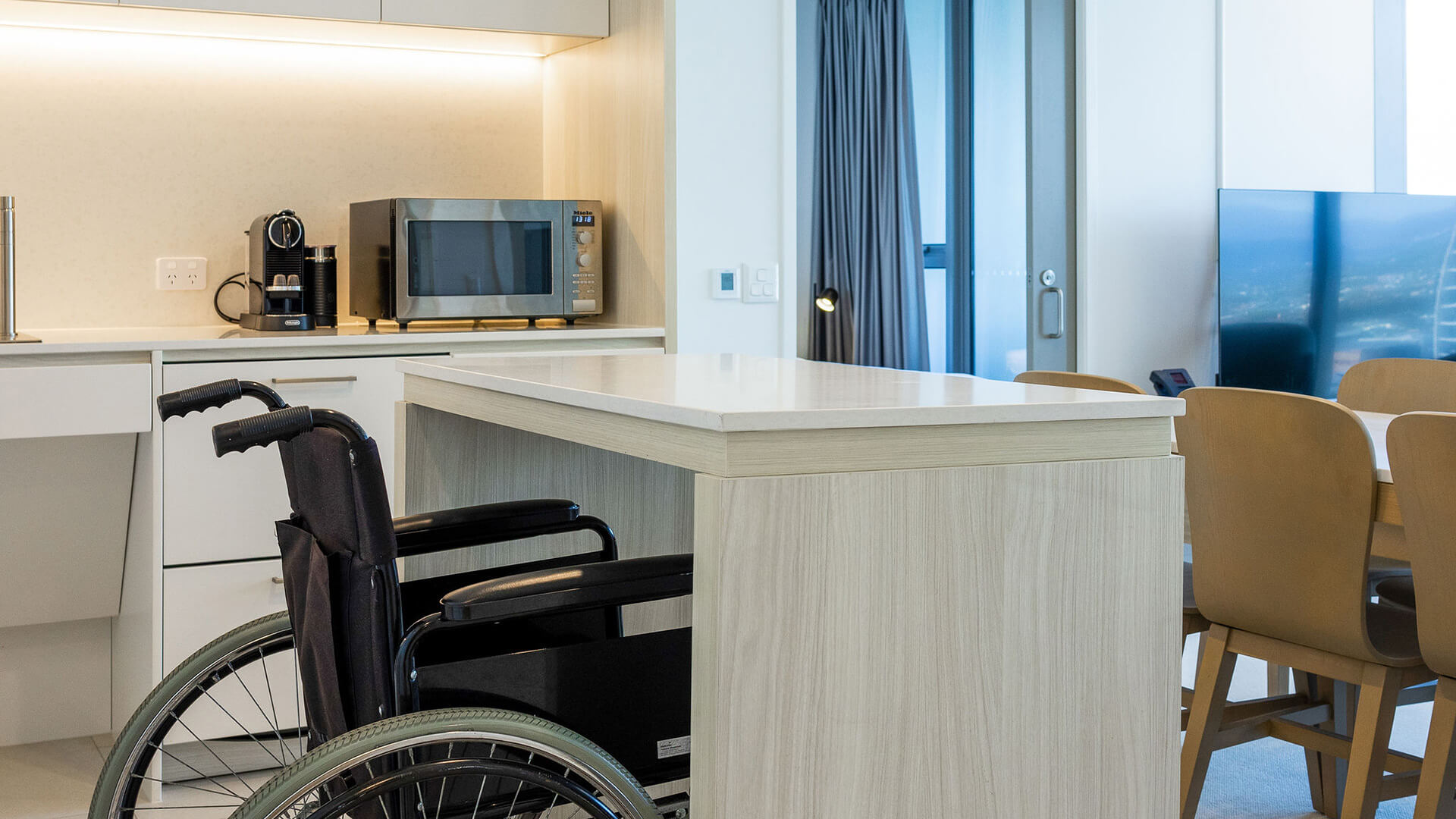 Wheelchair-accessible kitchen with oven and sink in 2 Bedroom Accessible Suite at ULTIQA Signature at Broadbeach.