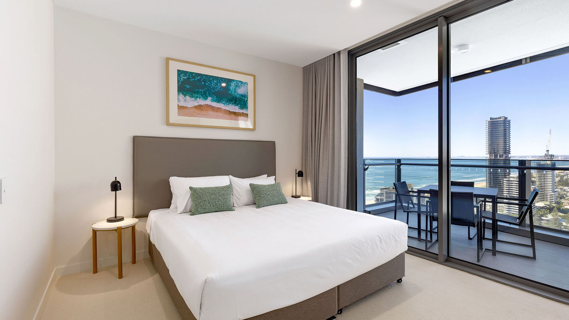 Bedroom with king bed and ocean-view balcony in the 2 Bedroom Ocean View Suite at ULTIQA Signature at Broadbeach.