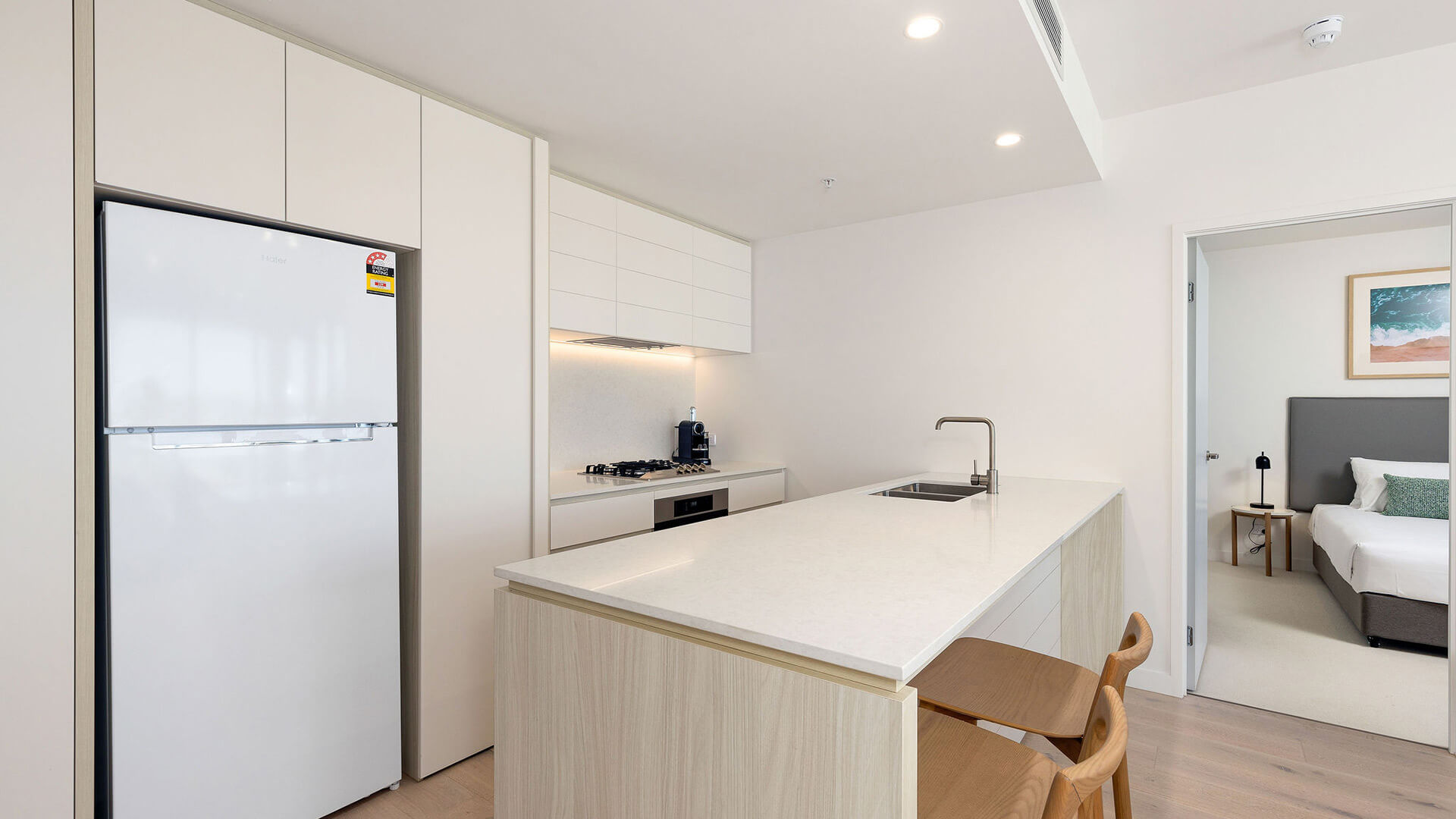 Modern kitchen with breakfast bar in the 2 Bedroom Ocean View Suite at ULTIQA Signature at Broadbeach.
