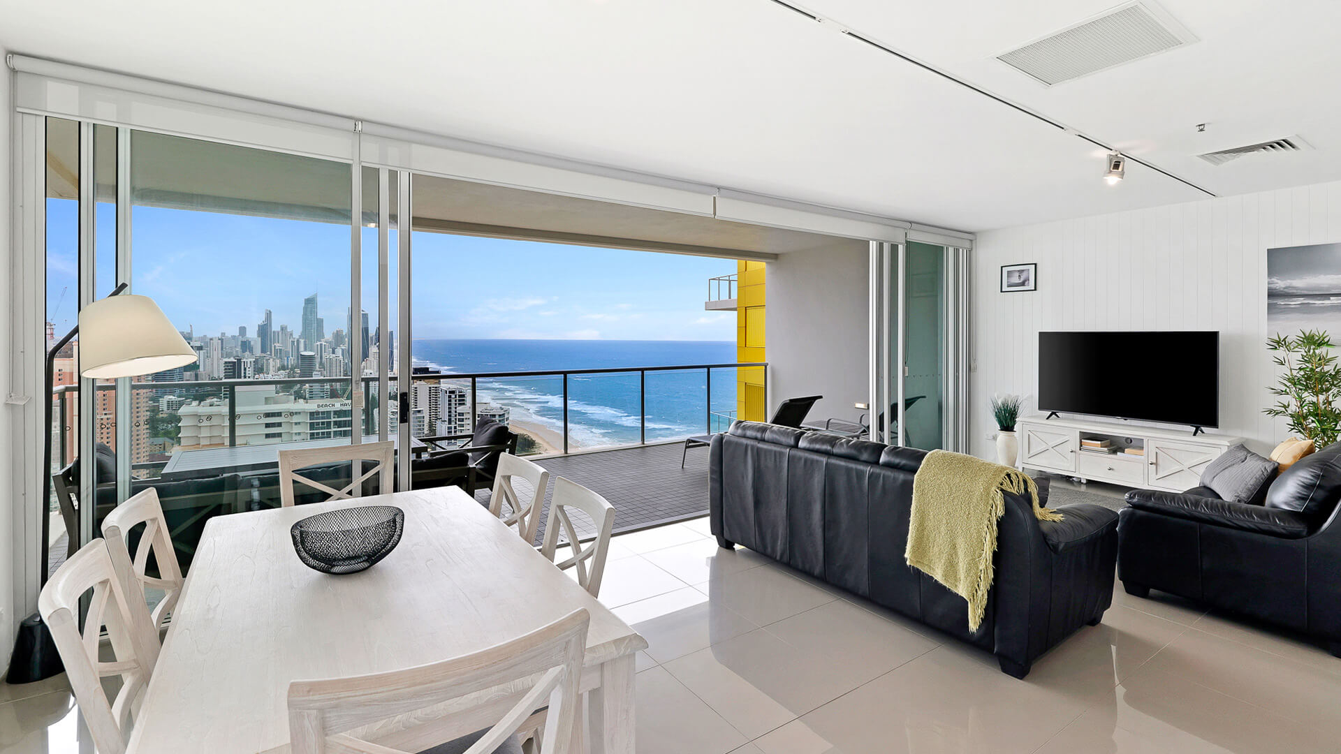 Living and dining area with ocean and skyline views in 2 Bedroom Gold Coast View Suite at ULTIQA Air on Broadbeach.