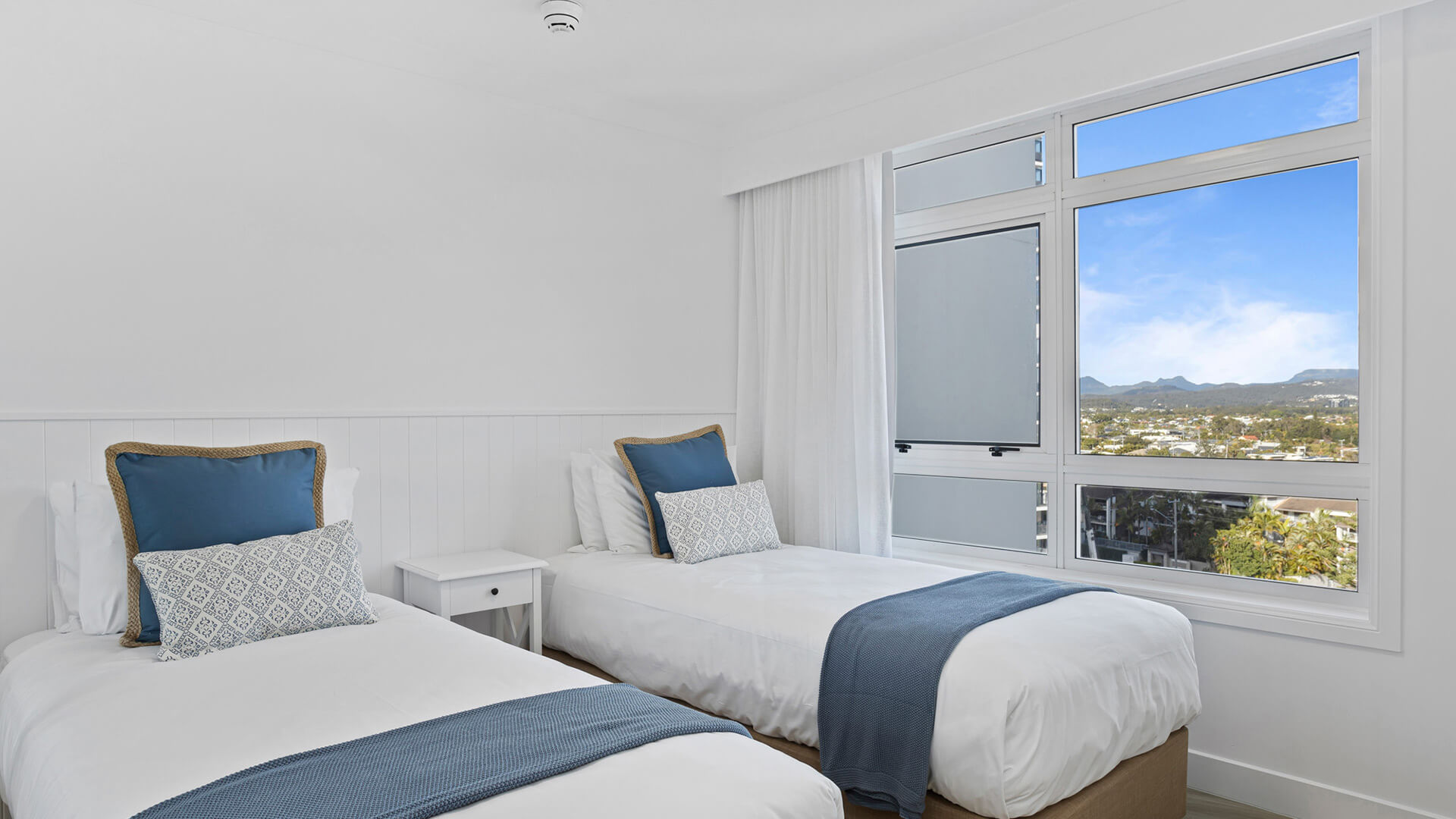 Twin bedroom with scenic views in the 3 Bedroom Superior Ocean View Apartment at ULTIQA Burleigh Mediterranean Resort.