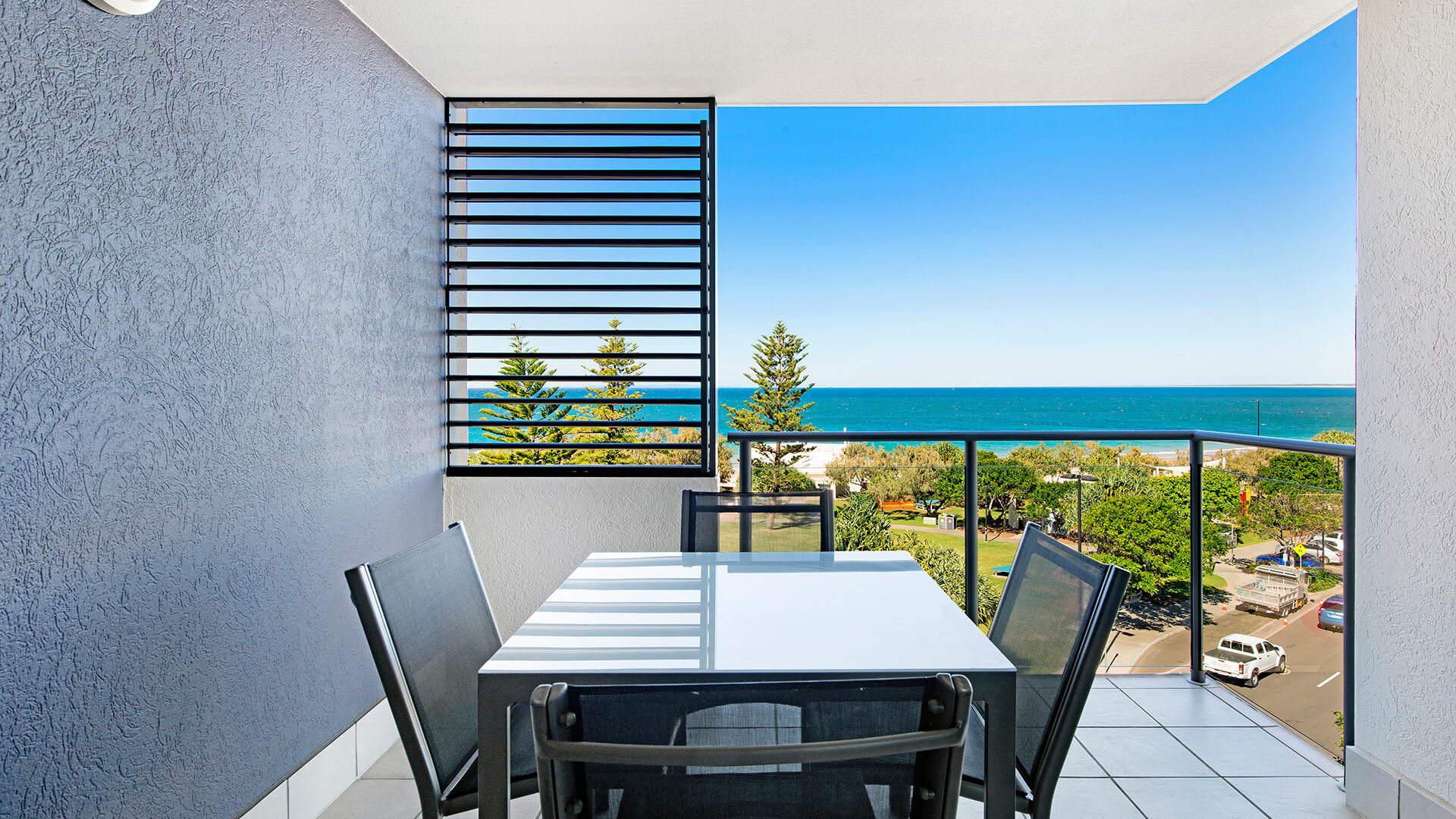 Private balcony with outdoor dining and ocean views in 1 Bedroom Apartment at ULTIQA Shearwater Resort.