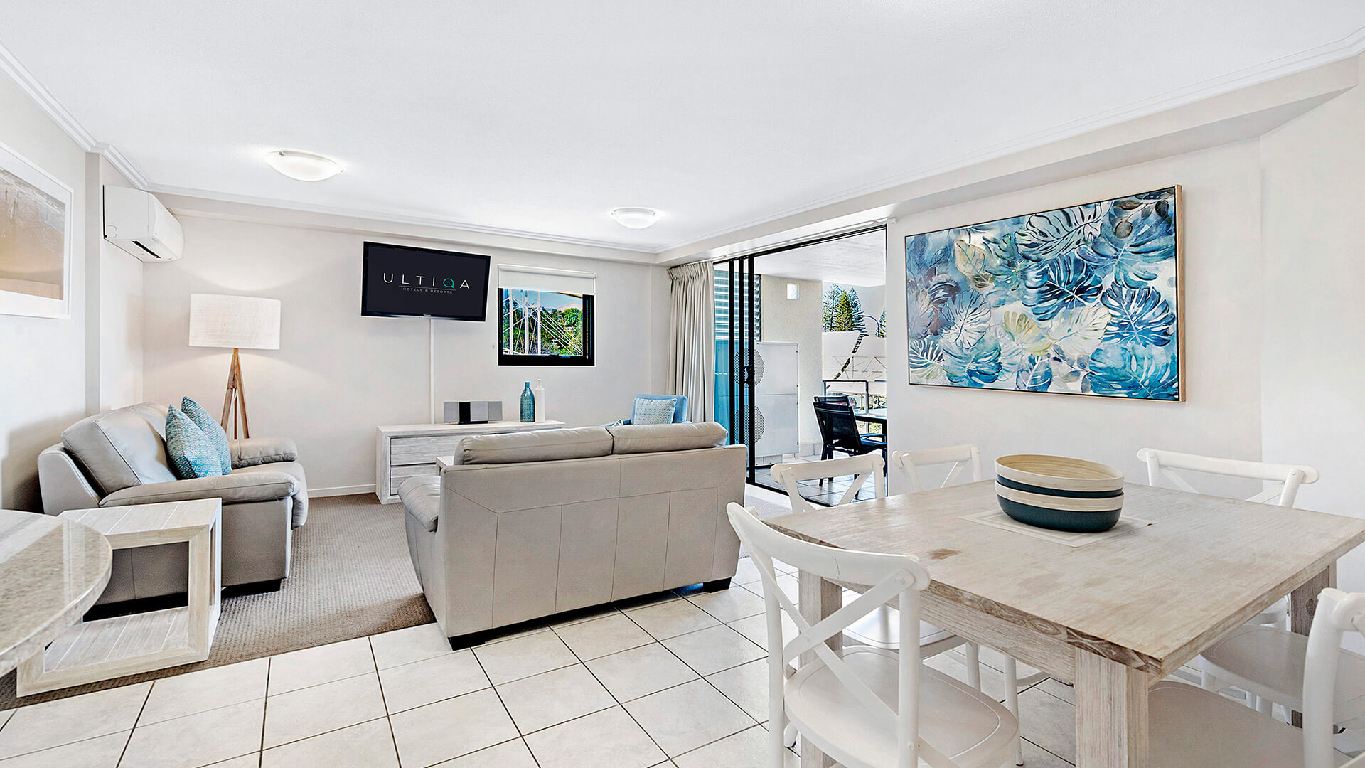 Dining and living area with balcony access in 3 Bedroom Dual Key Apartment at ULTIQA Shearwater Resort.