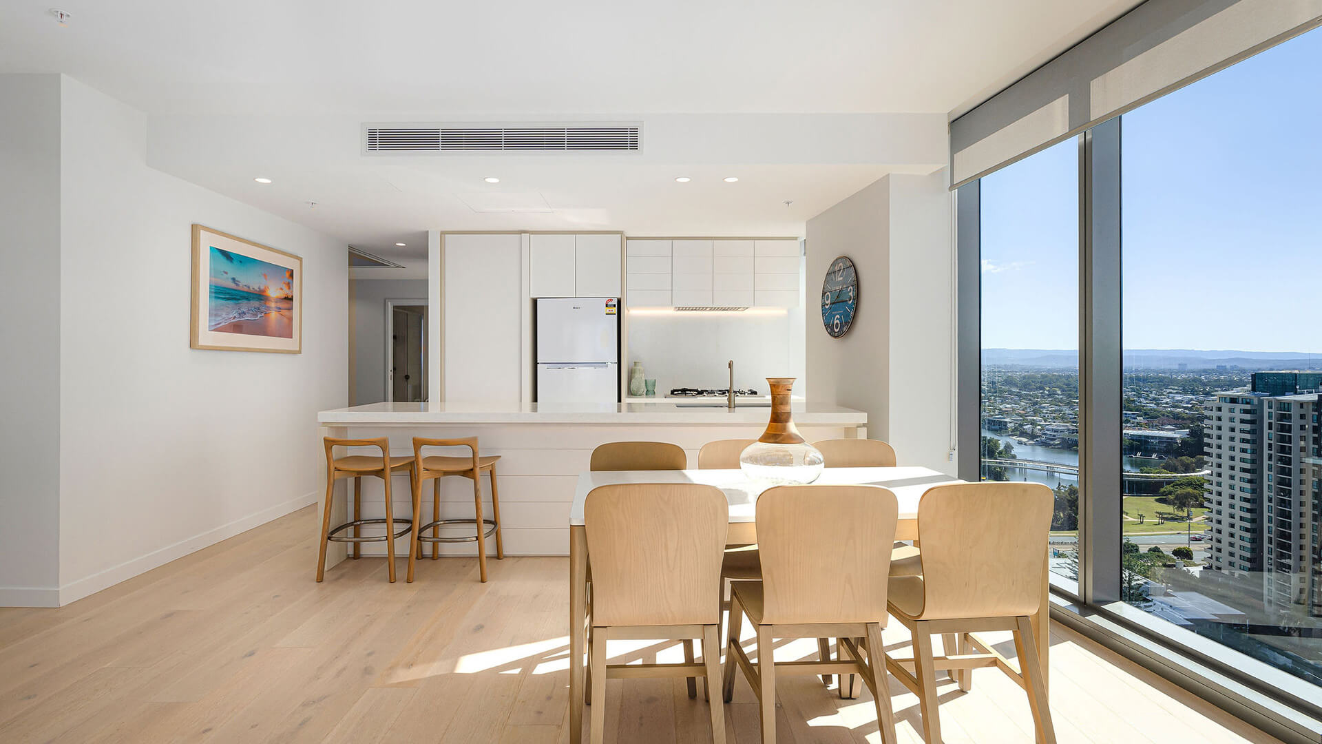 Dining area and kitchen with city views in 2 Bedroom Ocean View Suite Premium at ULTIQA Signature at Broadbeach.