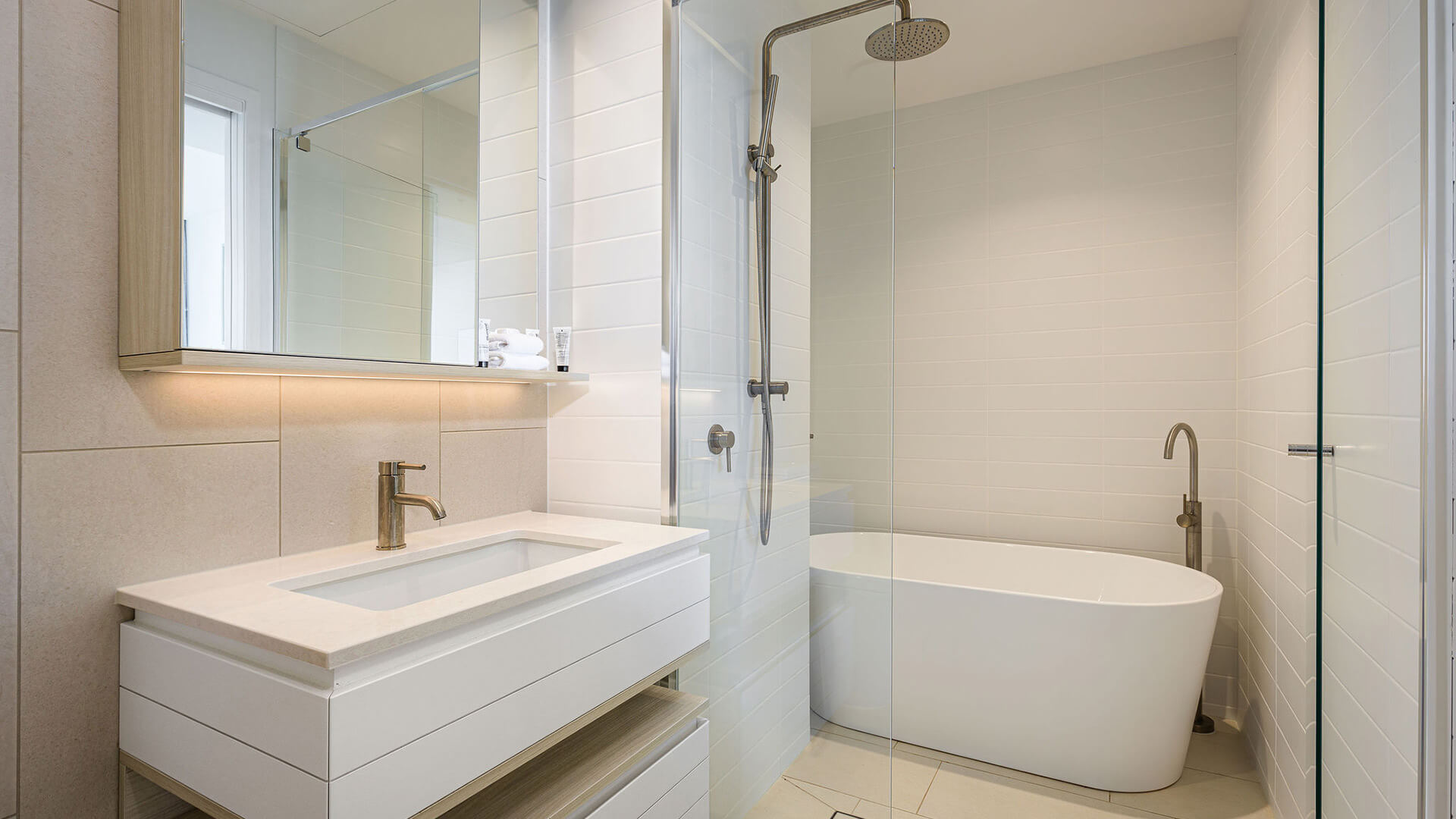 Modern bathroom with bathtub and walk-in shower in 2 Bedroom Ocean View Suite Premium at ULTIQA Signature at Broadbeach.