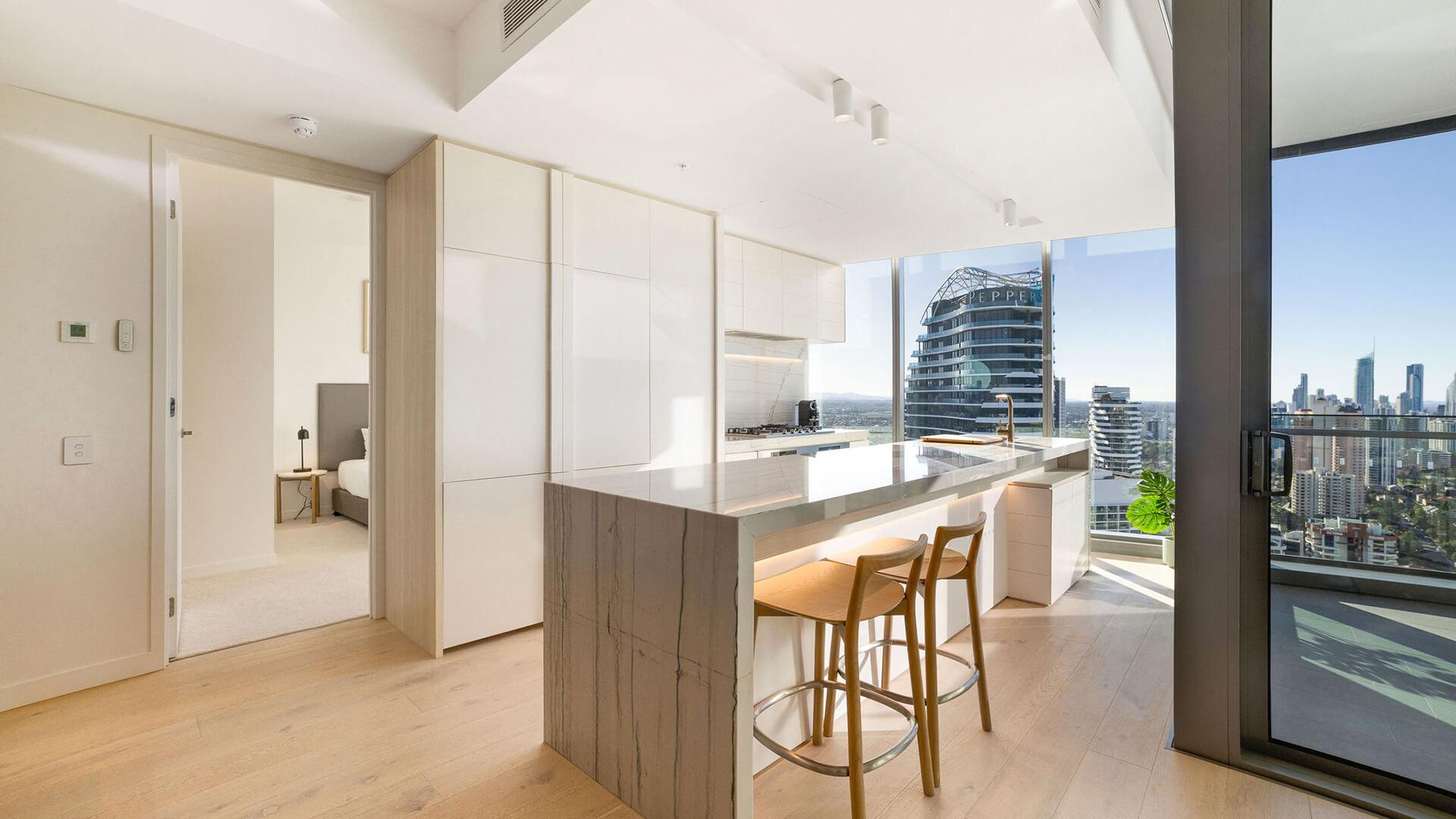 Kitchen in the 3 Bedroom Ocean View Suite at ULTIQA Signature at Broadbeach, with city and balcony views.
