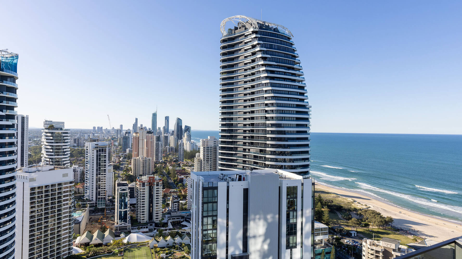 View from the 3 Bedroom Ocean View Suite at ULTIQA Signature at Broadbeach, showing city skyline, river, and distant hills under a clear blue sky.